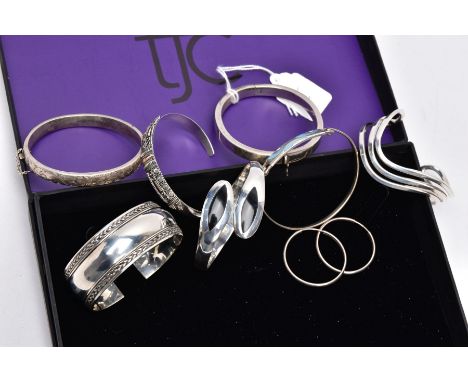 A COLLECTION OF SILVER AND WHITE METAL BANGLES AND A PAIR OF HOOP EARRINGS, to include a silver openwork wave bangle, hallmar