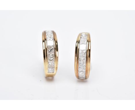 A PAIR OF 9CT GOLD DIAMOND HUGGIE EARRINGS, each designed with a row of channel set princess cut diamonds, total estimated di