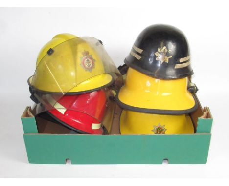Five British vintage firefighter helmets of various styles and eras, including c1960s Warrington helmet, a Nottinghamshire Cr