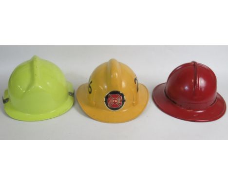 Three vintage American Fireman helmets, including an Orange County c1978 MSA pattern helmet, a c1991 Poss USAF Cairns and Bro