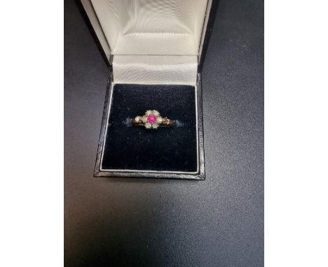 A 19th century yellow metal diamond and ruby cluster ring, set central old mine cut ruby surrounded by six mine cut diamonds 