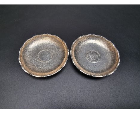 A pair of Chinese white metal coin inset dishes,&nbsp;by Wai Kee Hong Kong, stamped 'Sterling Silver', 7.7cm diameter. 