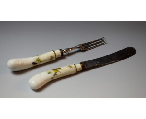 A 19th century German porcelain-hafted dessert knife and fork, possibly Meissen, the pistol grips painted with birds on branc