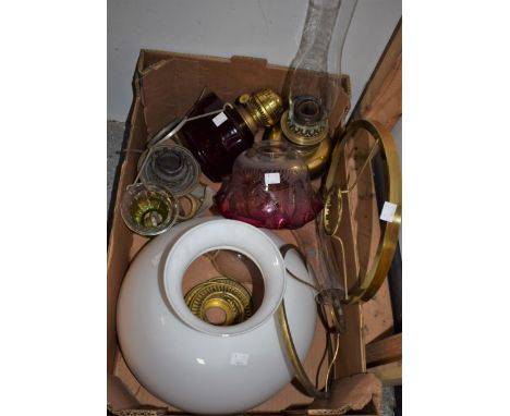 A Victorian brass oil lamp; a ruby glass oil lamp reservoir; a cranberry glass oil lamp shade; other shades, fittings, etc