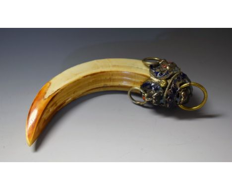 A 19th century Chinese enamel and white metal-mounted boar's tusk, the pommel boldly cast with a shishi mask and ring, the si