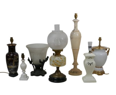 A group of table lamps, including an Edwardian oil lamp, 55cm high, an early 20th century cast iron lamp with frosted glass s