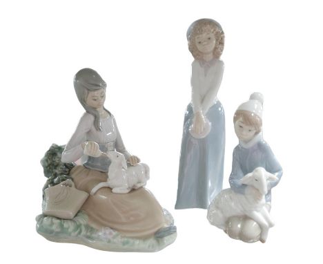 A Lladro figurine of a girl bottle feeding lamb, 17 by 13.5 by 17cm high together with another Lladro figurine of a shepherd 