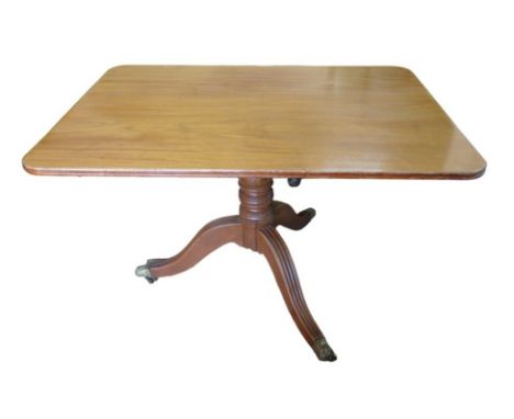 An Edwardian mahogany breakfast table, with rectangular top and tripod base with reeded legs and castors, 114.5 by 84.5 by 72