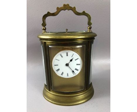 French oval brass-cased chiming carriage clock, white enamel dial with Roman numeral hour markers,bevelled glass panels, orig