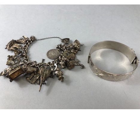 Silver Charm bracelet and many silver charms along with a heavy hallmarked silver bangle (total weight 137g)