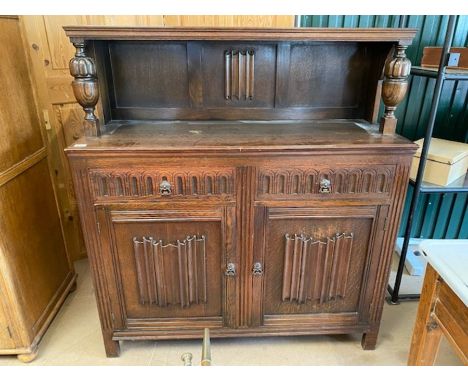 Small, carved, dark wood sideboard with shelf above, two drawers and shelving under 