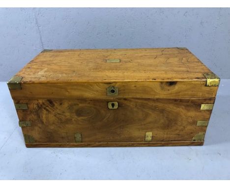 Light wood brass bound campaign chest with brass handles and unmarked brass cartouche to lid (repairs required to hinges)