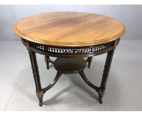 Antique occasional table with fret work design on four legs each comprising four supports and original castors, supporting a 