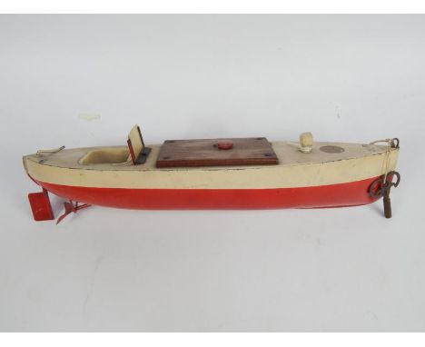 An early 20thC pond yacht, Sutcliffe model in metal with wooden top, realistic deck and key wind action with articulated rudd