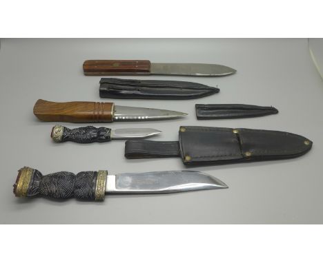 A two-knife set in scabbard, the ends set with orange stone and two other knives with scabbards 