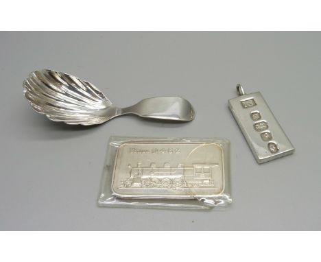 A silver ingot pendant, one other silver ingot and a silver caddy spoon hallmarked London 1935 and with small crease and crac