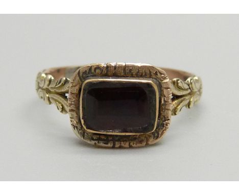 An antique yellow metal ring set with a cut garnet, 1.4g, L 
