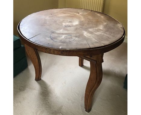 An unusual wooden table made of a cross section of tree trunk on associated base. 