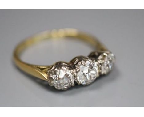 An 18ct and plat set three stone diamond ring, size M/N, gross 2.8 grams, the largest approx. 5mm in diameter with a depth of