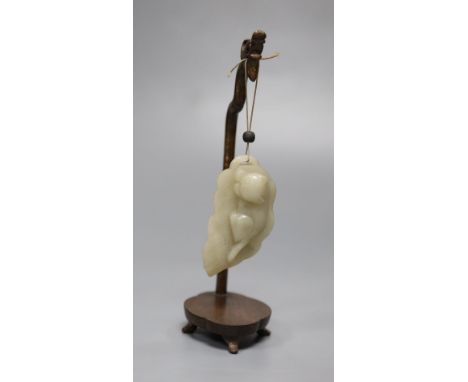 A 19th century Chinese celadon jade figure of a cat on a leaf, wood stand, height 17cm
