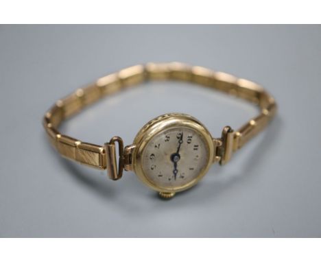A lady's 9ct gold manual wind wrist watch, on a gold plated bracelet, gross 14.3 grams.