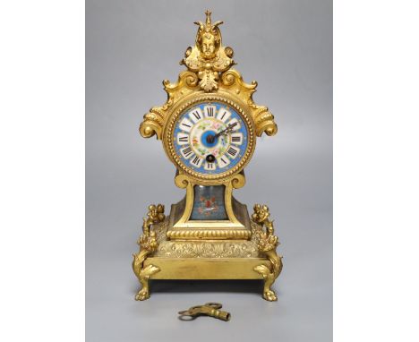 A 19th century French gilt metal mantel timepiece, with ceramic dial, pendulum and key, 31cm