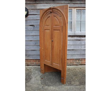 A late 18th century architectural pine arch top corner cupboard enclosed two panel doors, on stile supports, 38" wide x 18" d