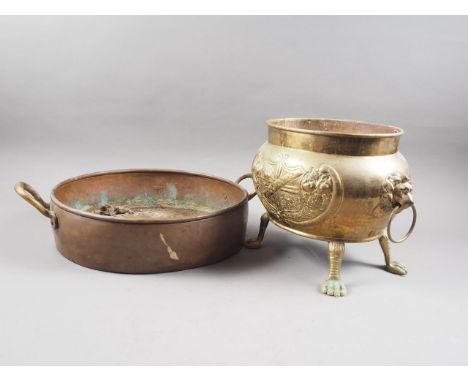 An embossed brass two-light mask-handled jardiniere, on paw feet, 9" high, and a copper and brass two-handled preserve pan, 1