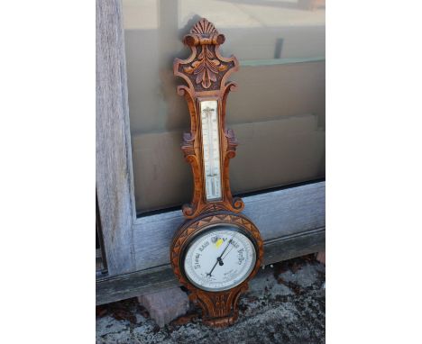 A light oak cased barometer and thermometer with carved decoration, 34 1/2" high 