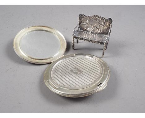 A Continental silver miniature model of a bench with embossed decoration and an engine turned silver Kigu powder compact 