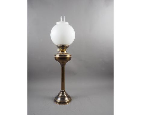 A brass oil lamp with frosted globe shade 