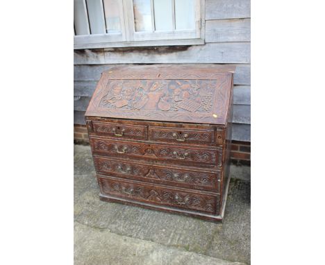 An 18th century and later carved oak fall front bureau, inscribed Ben Johnson, fitted four long graduated drawers, on bracket