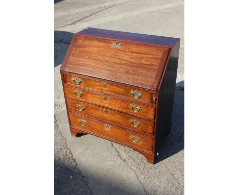 A Georgian mahogany and box line inlaid fall front bureau with fitted interior over four long graduated drawers, on bracket f