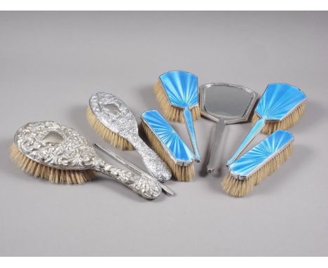 A silver and enamel dressing table set and two embossed silver backed brushes 