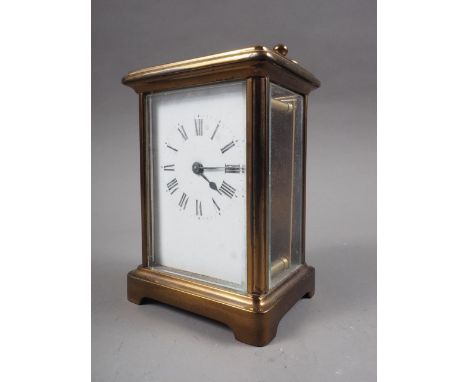 A brass cased carriage clock with white enamel dial and Roman numerals, 4 3/4" high 
