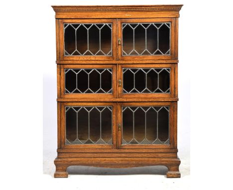 An early 20th Century Simpoles chapter three tier oak stacking bookcase Having a dentil frieze above three tiers, each with a