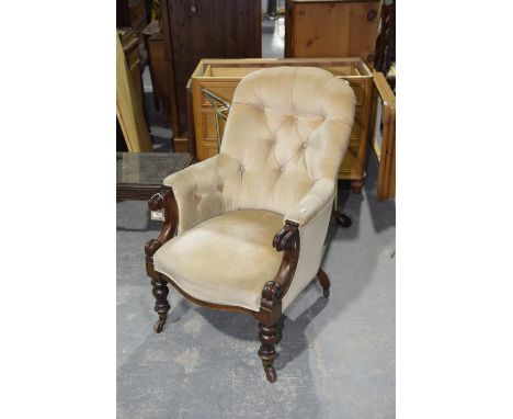 A Victorian mahogany framed and button back drawing room chairThe arched button back above padded arms terminating in carved 