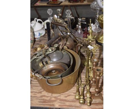 A large group of metal waresTo include two copper kettles, brass jam skillet, a chamber stick stand, a horse bit, brass fires