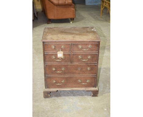A Georgian oak commode chestThe rectangular moulded folding top enclosing a vacant interior with an arrangement of two short 