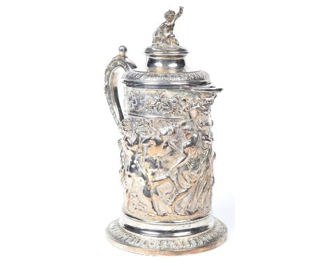 An Impressive 19th Century silver plated lidded jug by John Grinsell & Sons  The tapering cylindrical body embossed with vari