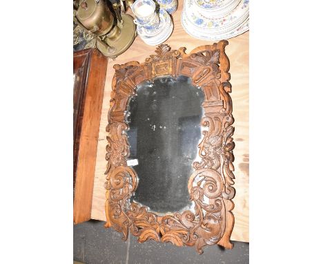 An oak relief carved decorative wall mirrorThe wall mirror with scrolling borders, parrot head detail and leafy crest surroun