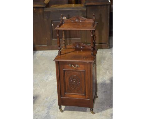 A later Victorian walnut coal purdoniumThe upper galleried shelf supported on ring incised turned spindles above a carved fal