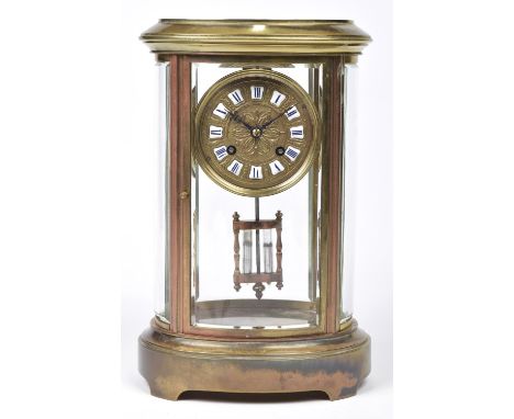 A late 19th Century French oval brass four glass mantle clock with mercury filled pendulumThe 10cm gilt dial with white ename