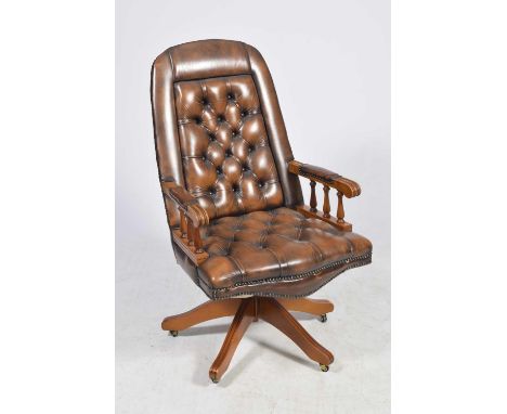 A brown leather button back swivel office chair, 20th CenturyHaving an arched and padded button back above stained beech wood