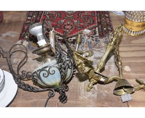 An early 20th Century hanging lamp with a Vaseline glass reservoirThe reservoir supported in a wrought iron scrolling frame w