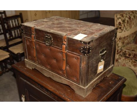 A stained hardwood and padded leather trunkThe rectangular trunk with studded leather panels and applied with leather straps 