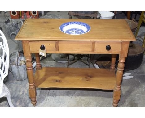 A pine wash standThe rectangular moulded top centred with a circular aperture and blue and white ceramic bowl above two friez