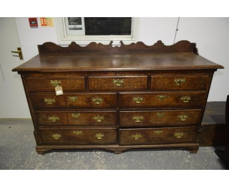 A George III oak and mahogany crossbanded Lancashire mule chestHaving a shaped raised back above a rectangular moulded hinged