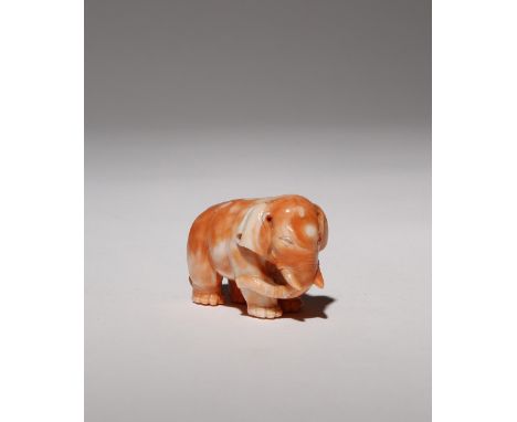 A CHINESE CORAL CARVING OF AN ELEPHANT LATE QING DYNASTY The animal depicted standing four-square, swaying its trunk and tail