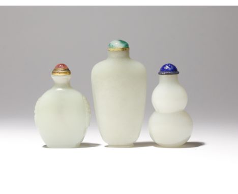 THREE CHINESE JADE SNUFF BOTTLES QING DYNASTY Comprising: a pale celadon flattened snuff bottle which tapers towards the foot